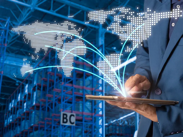 Professional using a tablet in front of a global shipping network graphic