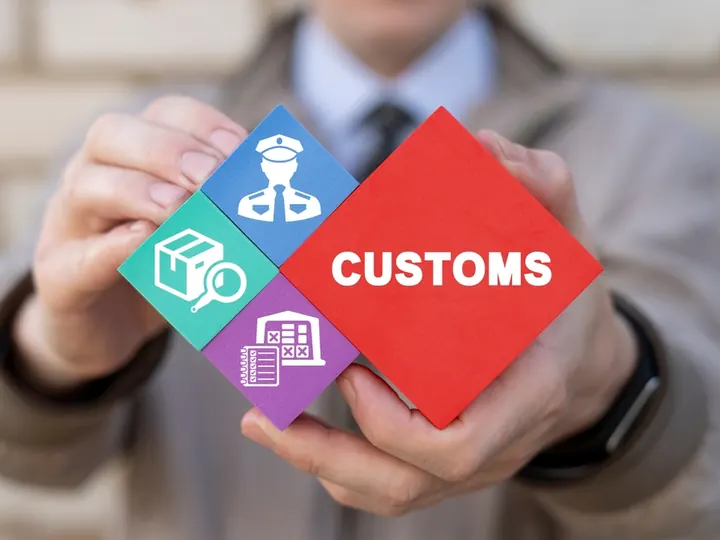 Hands holding a block marked customs