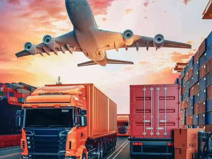 Cargo aircraft and delivery trucks at sunset